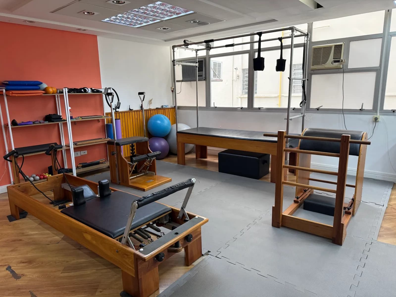 Estúdio de Pilates da Vyta na unidade Consolação, com os aparelhos de pilates sendo eles reformer, cadillac e chair, com parede de fundo na cor coral.