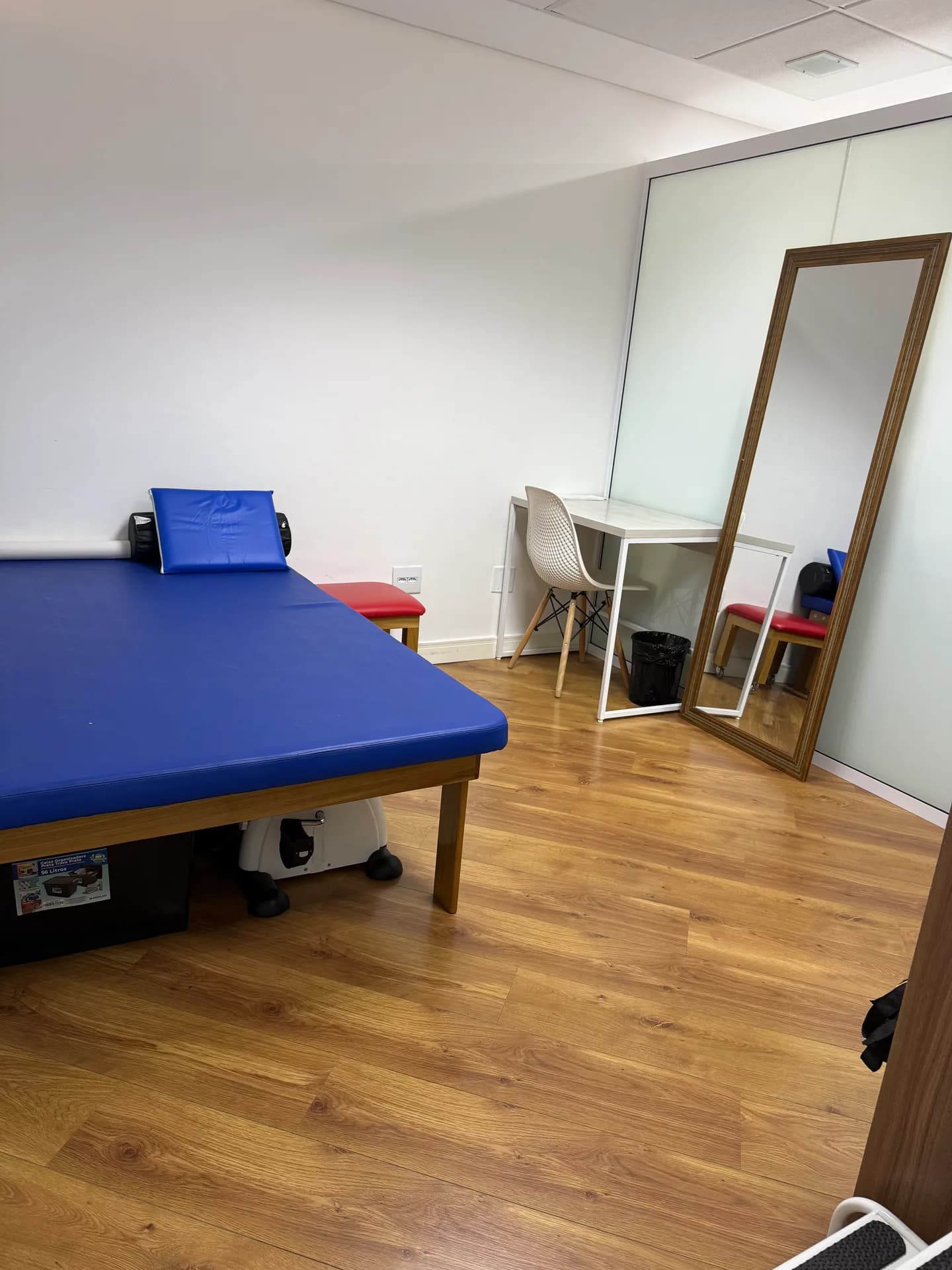 Sala de atendimento da unidade Consolação da Vyta, com tablado azul de tratamento e espelho de corpo inteiro